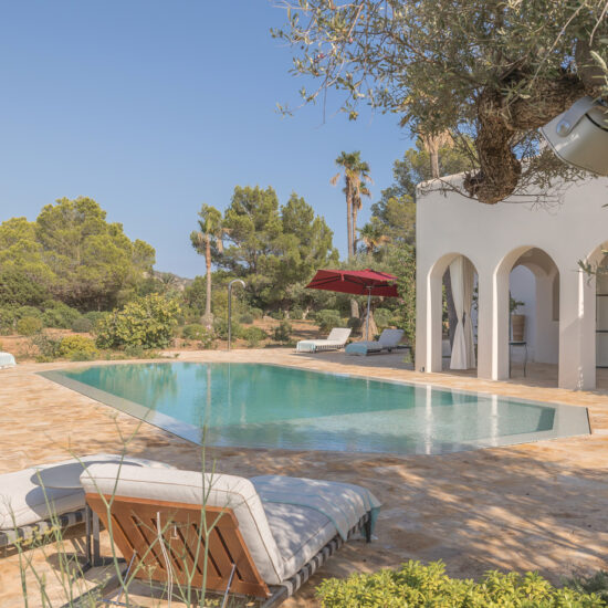 Elegant outdoor pool area with lounge chairs and Mediterranean-style architecture.
