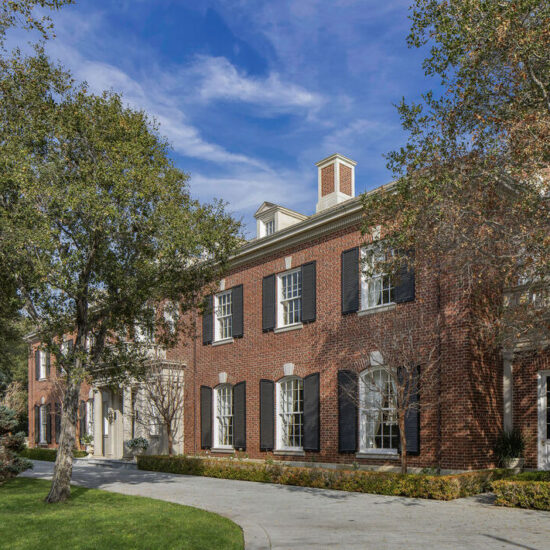 Elegant brick building with classic windows and a clear blue sky.