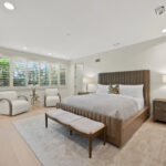 Elegant bedroom with large windows and cozy seating area.