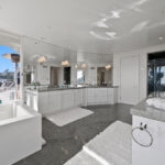 Bright modern kitchen with white cabinetry and marble countertops.