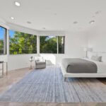 Bright, modern bedroom with large windows and minimalist decor.