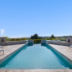 Luxurious infinity pool overlooking a scenic landscape under clear blue sky.