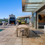 Modern outdoor patio with dining area and fireplace.