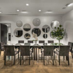 Modern dining room with a long table and circular wall mirrors.