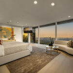 Luxurious bedroom with panoramic city views and modern decor.