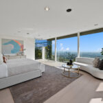 Modern living room with panoramic city views and minimalist decor.